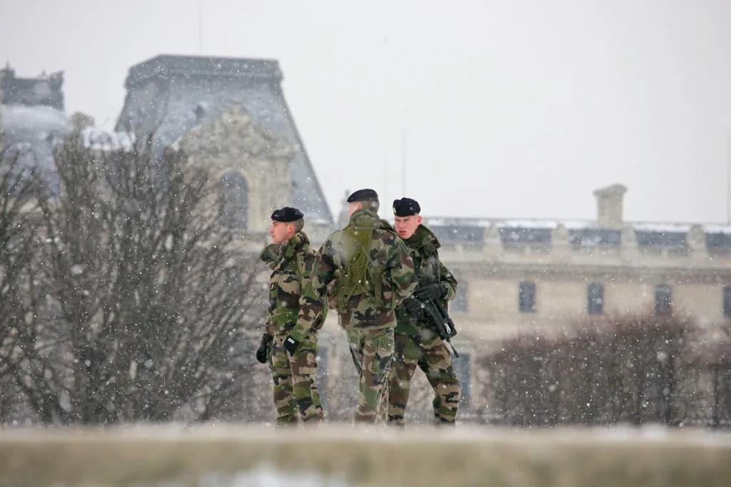 Militaires en patrouille Vigipirate sous la neige près du Louvre à Paris
