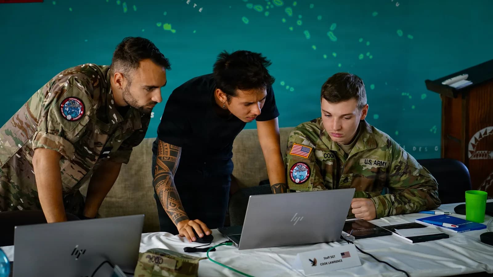 Adjudant français des FANC, civil cyber tahitien et spécialiste cyber américain devant leurs ordinateurs, exercice Marara en Polynésie française