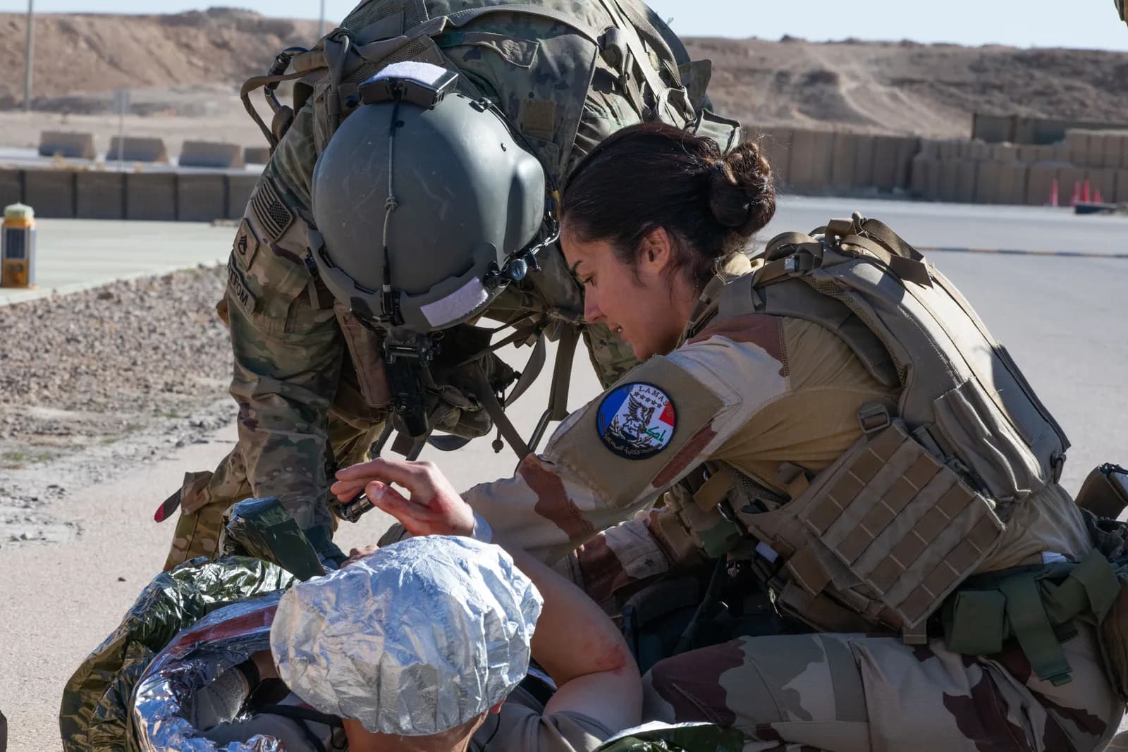Militaire française et soldat américain prenant en charge une victime simulée, exercice medevac en Irak