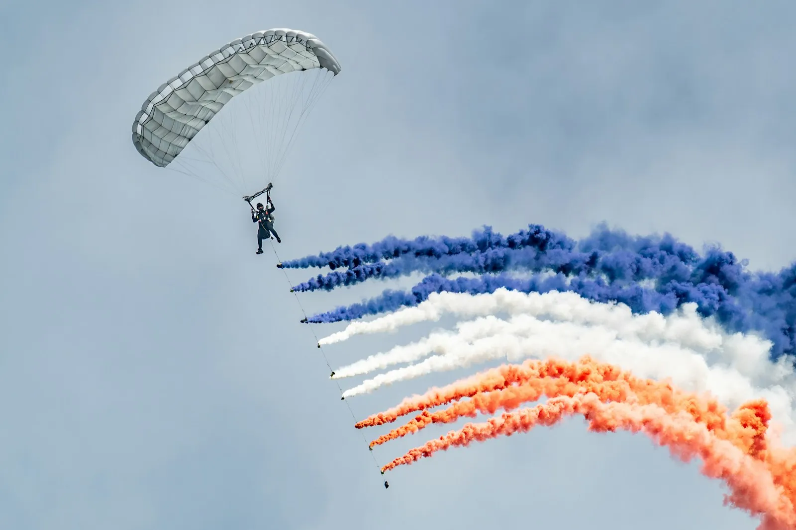 Parachutiste en démonstration avec fumigènes bleu-blanc-rouge