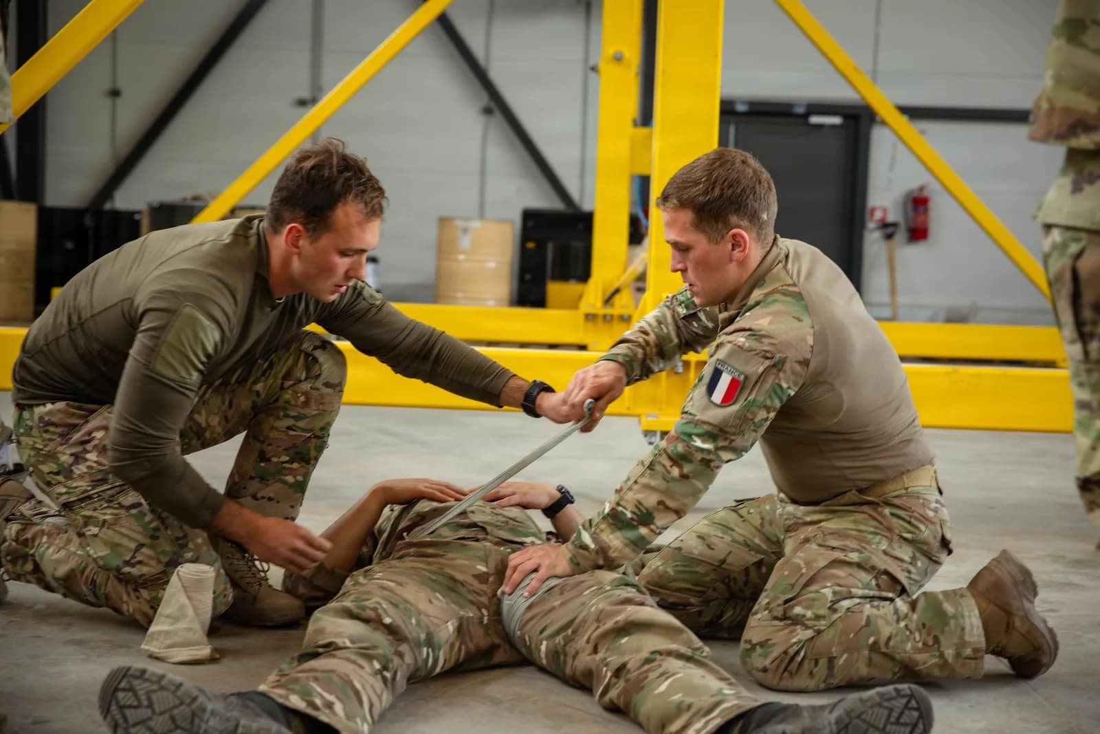 Soldats français démontrant la pose d'un pansement compressif lors d'une formation de secourisme au combat en Estonie